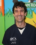 Photo of Dr. Jeffrey Stupine smiling in a black shirt in front of a colorful background